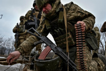 Ukrajinský vojak nakladá nábojnice do guľometného pásu počas útočných cvičení. FOTO: Reuters
