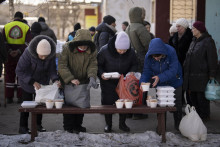 Starší ľudia čakajú na chlieb a teplé jedlo od humanitárnych organizácií v štvrti Saltivka v Charkove. FOTO: TASR/AP