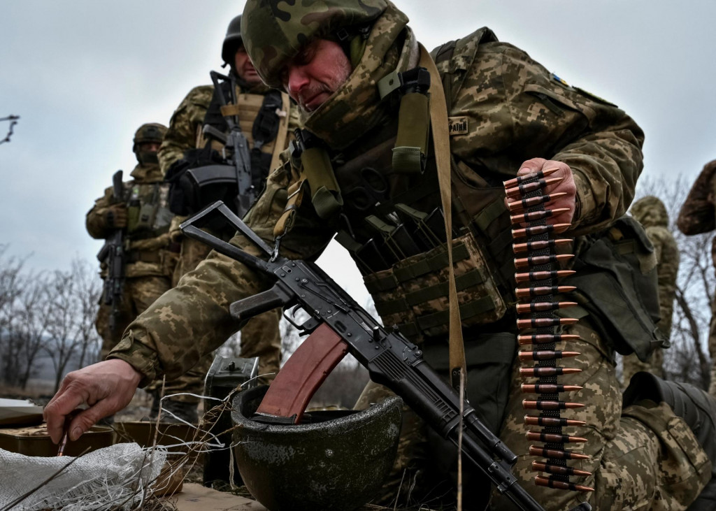 Ukrajinský vojak nakladá nábojnice do guľometného pásu počas útočných cvičení. FOTO: Reuters