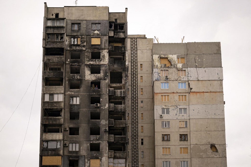 Pohľad na zničenú obytnú budovu, ktorú robotníci opravujú po ruskom ostreľovaní. FOTO: TASR/AP