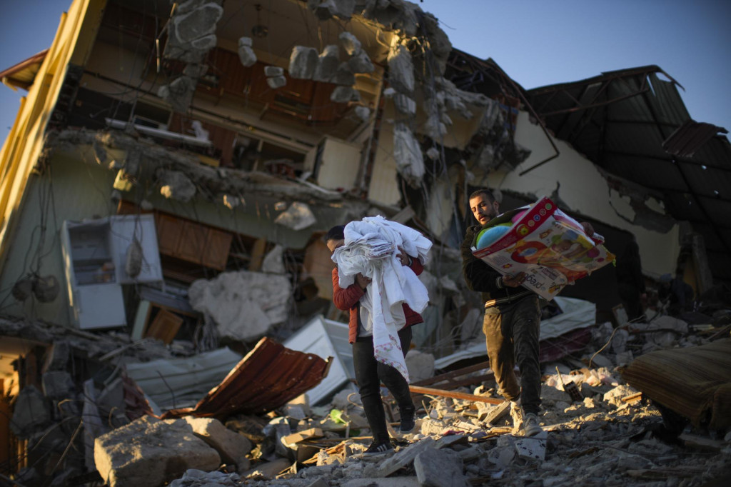 Miestni obyvatelia si odnášajú osobné veci zo svojho domu, ktorý zničilo ničivé minulotýždňové zemetrasenie v meste Samandag na juhu Turecka. FOTO: TASR/AP