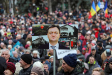 Demonštranti držia transparent s podobizňou nového moldavského premiéra Dorina Receana. FOTO: Reuters