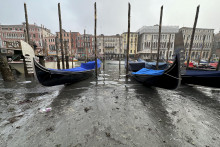 Gondoly kotvia počas nízkej hladiny vo vodných kanálov v Benátkach v sobotu 18. februára 2023. FOTO: TASR/AP