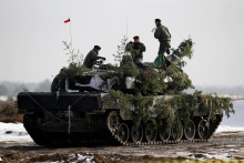 Vojaci poľskej armády na vrchole svojho tanku Leopard 2A4.  FOTO: Reuters