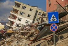 Zničená budova sa nakláňa na vedľajší dom po ničivom zemetrasení v meste Samandag na juhu Turecka. FOTO: TASR/AP