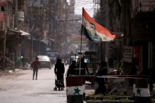 Štátna vlajka zobrazujúca obraz sýrskeho prezidenta Bašára al-Asada na kontrolnom stanovišti v Dúme na východnom predmestí Damasku v Sýrii. FOTO: REUTERS
