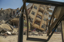 Zničená budova sa nakláňa na vedľajší dom po ničivom zemetrasení v meste Samandag na juhu Turecka. FOTO: TASR/AP