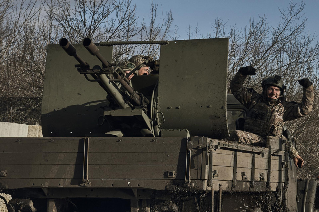 Ukrajinskí vojaci počas jazdy na armádnom vozidle v meste Bachmut. FOTO: TASR/AP


