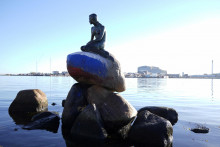 Socha Malej morskej víly, ktorú vytvoril sochár Edvard Eriksen podľa vzoru jeho manželky Eline, s ruskou vlajkou namaľovanou na kameni, na ktorom sedí. FOTO: Reuters