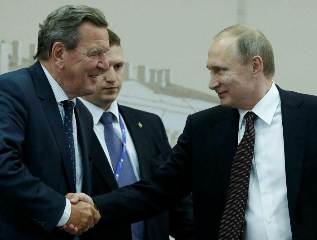 Ruský prezident Vladimir Putin si podáva ruku s bývalým nemeckým kancelárom Gerhardom Schröderom. FOTO: Reuters