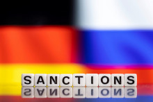 Nemecká a Ruská vlajka, v popredí nápis ”sankcie”. FOTO: Reuters