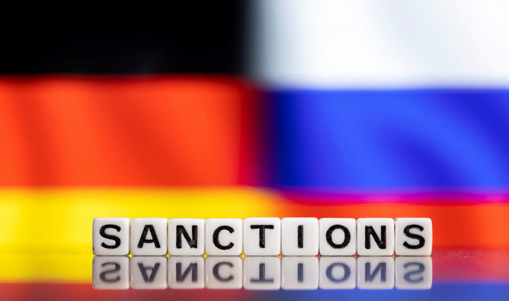 Nemecká a Ruská vlajka, v popredí nápis ”sankcie”. FOTO: Reuters