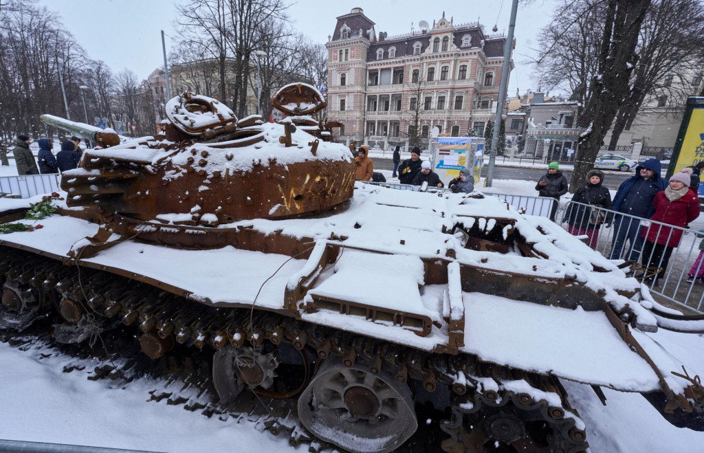 Ľudia si prezerajú zničený ruský tank T-72B, zabezpečený z ukrajinskej dediny Dmytrivka pri Kyjeve, vystavený pred ruským veľvyslanectvom v Rige v Lotyšsku 26. februára 2023. FOTO: REUTERS
