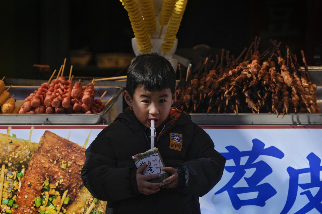 Dieťa v blízkosti obchodu s občerstvením na turistickej nákupnej ulici v Pekingu. FOTO: TASR/AP