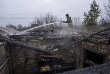 Hasič hasí požiar domu, ktorý bol zničený ruským ostreľovaním v ukrajinskom meste Kosťantynivka v Doneckej oblasti na východe Ukrajiny. FOTO: TASR/AP
