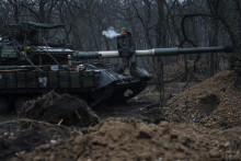 Ukrajinský vojak, ktorý stojí na vrchu tanku. FOTO: TASR/AP
