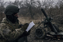 Vojak dobrovoľník sa pripravuje na streľbu na ruské pozície neďaleko mesta Bachmut v Doneckej oblasti na východe Ukrajiny. FOTO: TASR/AP