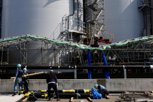 Pracovníci nosia prenosové potrubia, aby ich nainštalovali na zariadenie pre upravenú vodu Advanced Liquid Processing System v deaktivovanej jadrovej elektrárni Fukushima Dai-ichi v meste Okuma. FOTO: Reuters