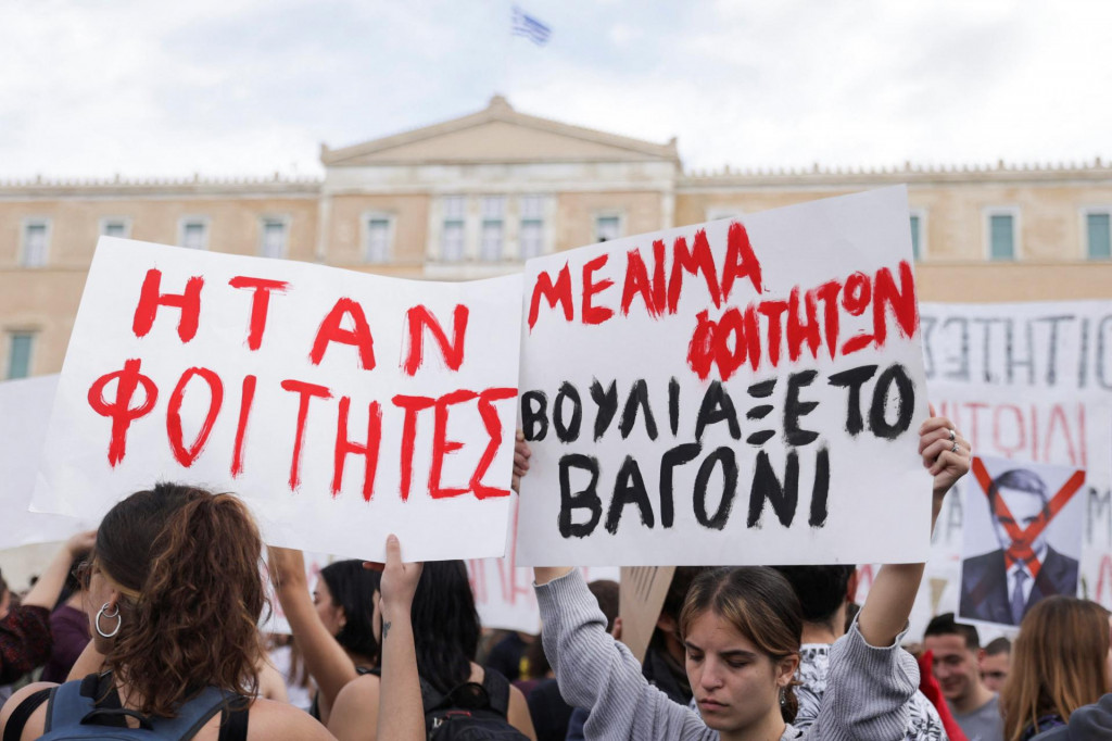 Demonštranti počas protestu pred budovou parlementu. Na transparentoch sa nachádzajú nápisy ”Boli to študenti” a ”Vagóny zaplavila študentská krv”. FOTO: Reuters