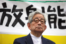 Nositeľ Nobelovej ceny za literatúru Kenzaburó Óe sedí pred transparentom s nápisom „radiácia“ počas protijadrového zhromaždenia v Tokiu 19. septembra 2011. FOTO: Reuters
