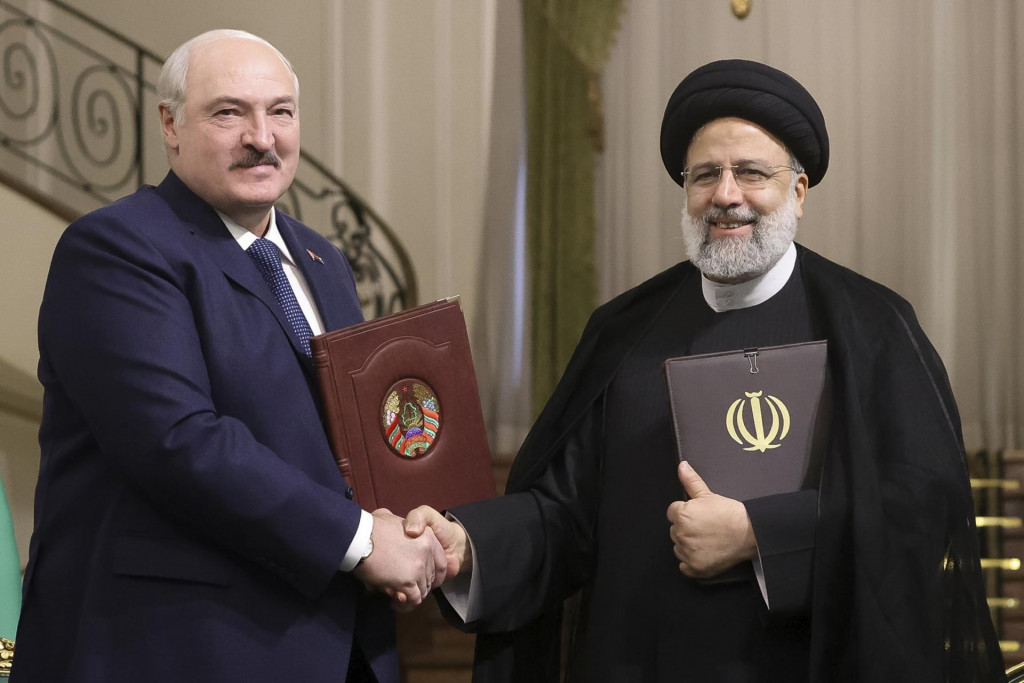 Iránsky prezident Ebráhím Raísí a bieloruský prezident Alexandr Lukašenko si podávajú ruky po podpise dohody o spolupráci. FOTO: TASR/AP