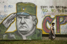 Žena prechádza okolo jedného z graffitov na podporu odsúdeného vojnového zločinca Ratka Mladiča. FOTO: Reuters