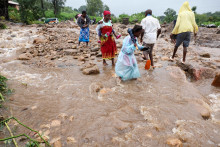 Miestni obyvatelia v okrese Chiradzulu prechádzajú zaplavenou cestou po zosuvoch bahna a skalách v oblasti spôsobených následkami cyklónu Freddy v Blantyre v Malawi. FOTO: Reuters