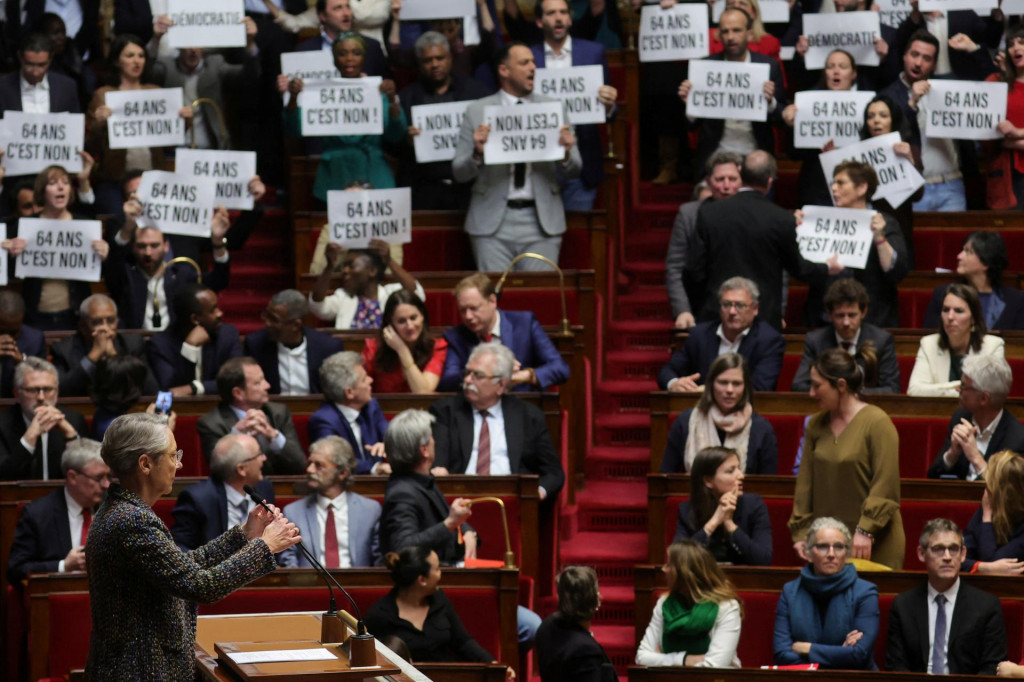 Poslanci parlamentu držia transparenty a spievajú Marseillaisu, francúzsku národnú hymnu, keď francúzska premiérka Elisabeth Borneová prichádza, aby sa zúčastnila na prejave o zákone o dôchodkovej reforme v Národnom zhromaždení v Paríži. FOTO: Reuters