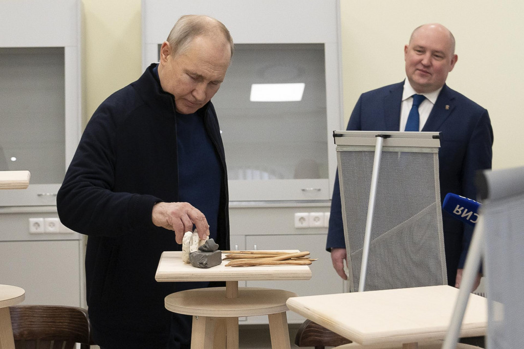 Ruský prezident Vladimir Putin (vľavo) a sevastopolský gubernátor Michail Razvožajev počas návštevy umeleckej školy v čiernomorskom prístavnom meste Sevastopol na Kryme 18. marca 2023. FOTO: TASR/AP