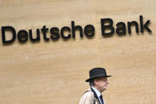 Bankár sa prechádza pred londýnskou pobočkou nemeckej veľkobanky Detsche Bank. SNÍMKA: REUTERS