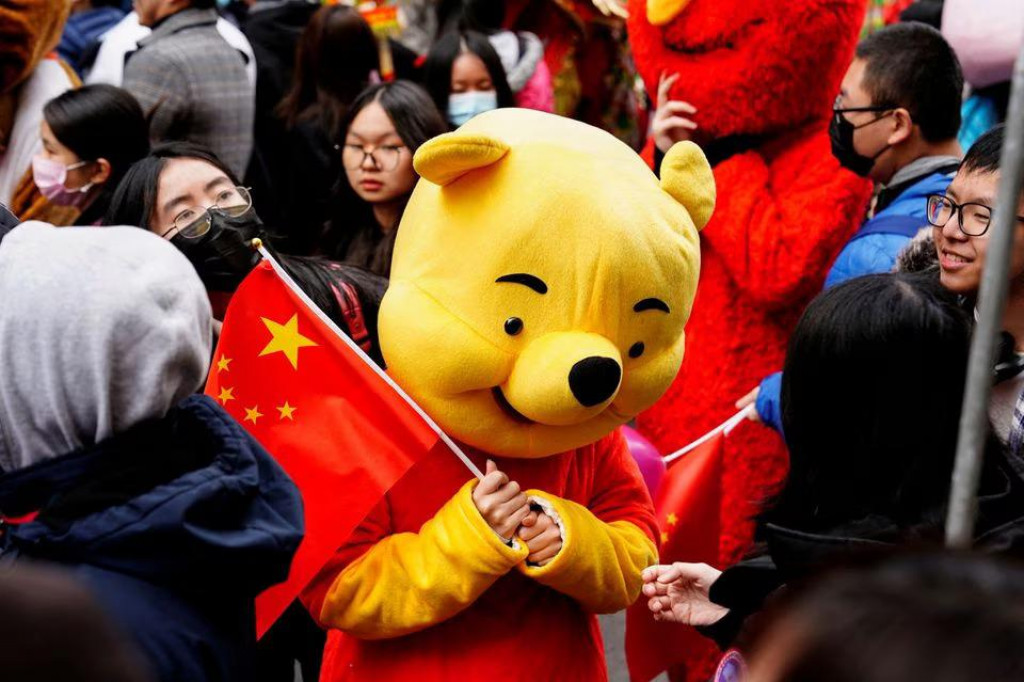 Medvedík Pú drží čínsku vlajku. FOTO: Reuters