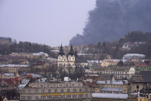 V pozadí stúpa dym po explózii v Ľvove, na západe Ukrajiny. FOTO: TASR/AP