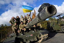 Ukrajinskí vojaci pózujú so svojou štátnou vlajkou na tanku Challeneger 2. Okrem týchto bojových vozidiel Briti Ukrajincom dodávajú aj náboje, vrátane protipancierových nábojov s ochudobneným uránom. FOTO: Reuters