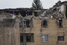 Príslušníci záchranných zložiek prehľadávajú trosky zničenej budovy po útoku dronu v meste Ržyščiv v Kyjevskej oblasti. FOTO: TASR/AP