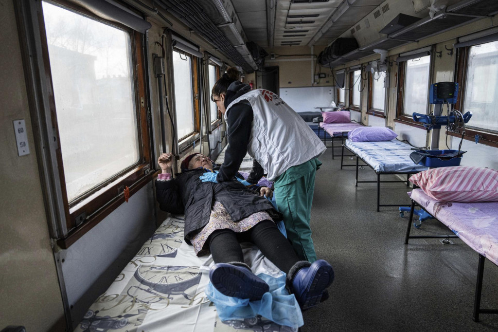 Pracovníčka medzinárodnej humanitárnej zdravotníckej organizácie Lekári bez hraníc sa rozpráva so staršou ženou v medicínskom vlaku MSF na železničnej stanici v meste Pokrovsk v Doneckej oblasti. FOTO TASR/AP
