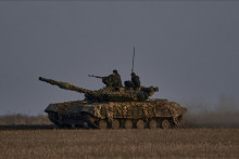 Ukrajinskí vojaci sa vezú na tanku na fronte v meste Bachmut. FOTO TASR/AP