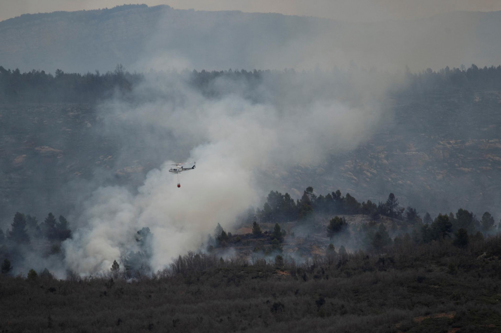 Vrtuľník zhodil vodu na lesný požiar v San Agustín v Španielsku. FOTO: Reuters