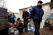 Obyvatelia plnia fľaše čerstvou pitnou vodou privezenou do okolia frontovej línie po tom, čo bola počas ruského útoku na Ukrajinu zasiahnutá kritická civilná infraštruktúra v Časiv Jar pri Bachmute. FOTO: REUTERS