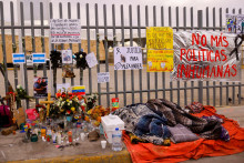 Migranti spia vedľa oltára pred záchytným centrom pre migrantov, kde niekoľko migrantov zomrelo po vypuknutí požiaru. FOTO: Reuters