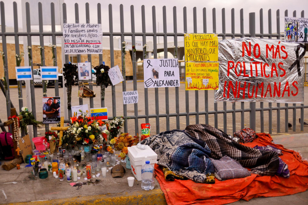 Migranti spia vedľa oltára pred záchytným centrom pre migrantov, kde niekoľko migrantov zomrelo po vypuknutí požiaru. FOTO: Reuters