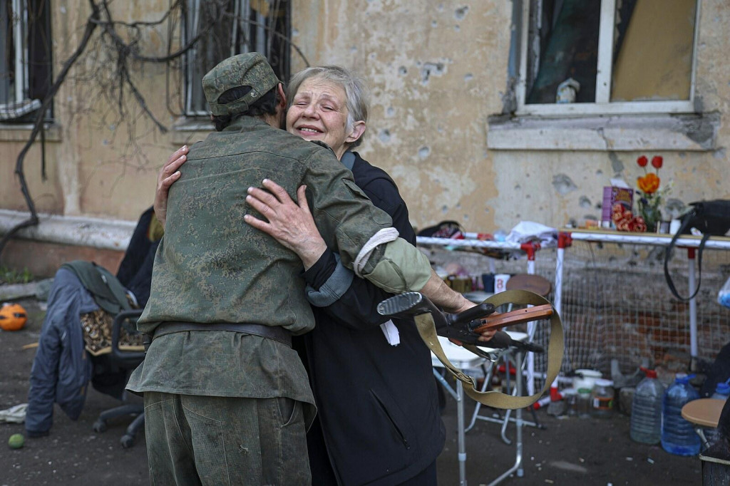 Obyvateľka Mariupolu objíma bojovníka Doneckej ľudovej republiky. FOTO: TASR/AP
