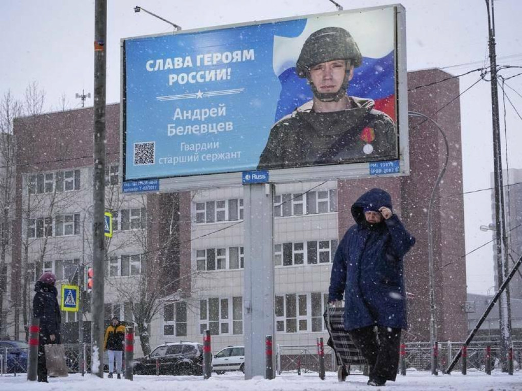 Žena kráča v Petrohrade okolo bilbordu s portrétom ruského vojaka a nápisom Sláva hrdinom Ruska. FOTO: Reuters