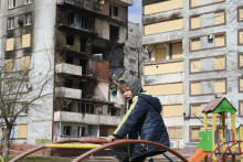 Zničená budova a chlapec v Doneckej oblasti na Ukrajine. FOTO: TASR/AP

