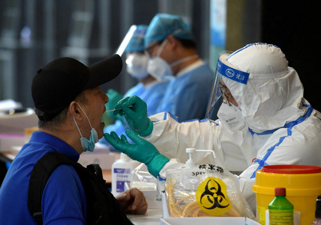 Zdravotnícky personál v ochrannom obleku zbiera výtery na testy nukleových kyselín. FOTO: Reuters