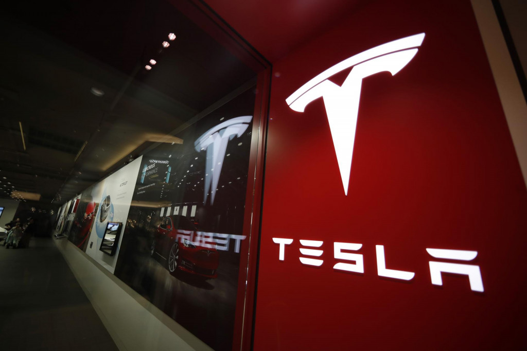 Logo amerického výrobcu elektromobilov Tesla pred predajňou v Denveri. FOTO: TASR/AP