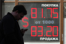 Muž stojí pred zmenárňou s výmenným kurzom amerického dolára voči rubľu v Petrohrade. FOTO: TASR/AP