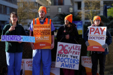 Mladí lekári držia transparenty počas štrajku pred nemocnicou St Thomas‘ Hospital v Londýne. FOTO: Reuters