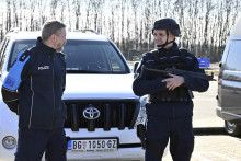 Srbský policajt  sa usmieva a rozpráva s príslušníkom európskej pohraničnej polície Frontex. FOTO: TASR/AP