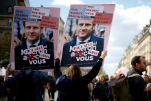 Demonštranti držia transparenty zobrazujúce francúzskeho prezidenta Emmanuela Macrona počas demonštrácie proti dôchodkovej reforme. FOTO: Reuters