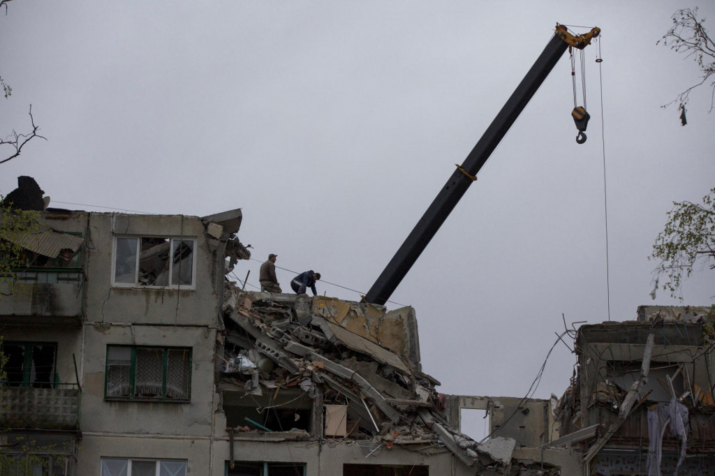 Dobrovoľníci pri práci v troskách obytnej budovy poškodenej ruským ostreľovaním ukrajinského mesta Sloviansk. FOTO: Reuters